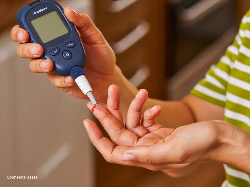 A person testing their blood sugar with a glucometer at home.