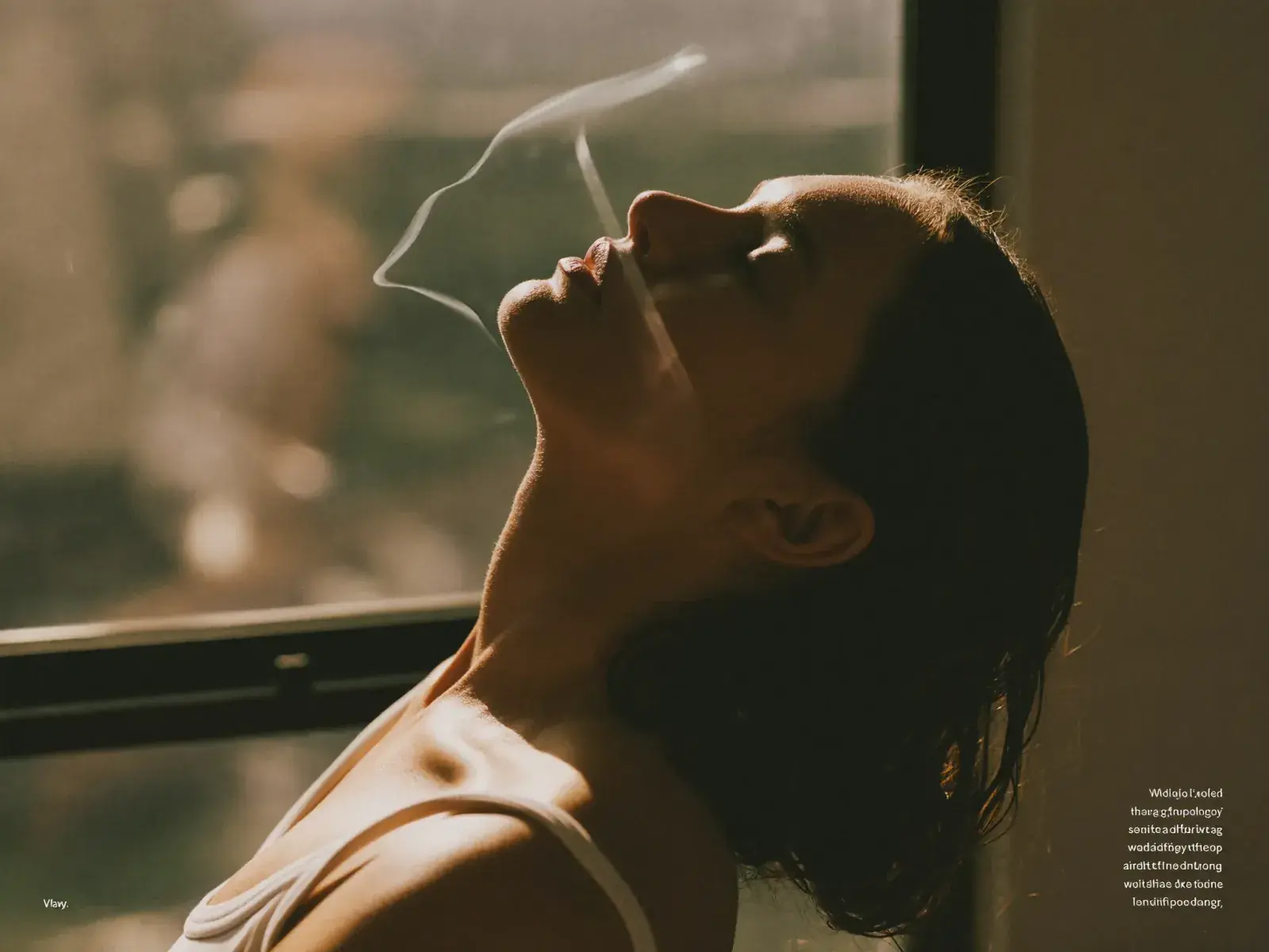A woman standing in warm morning sunlight by a window.