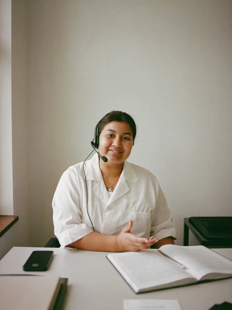 A nutritionist at a bright desk, mid-conversation on a headset.
